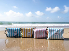 Load image into Gallery viewer, The FOLC Family Pack featuring four sand-free beach towels in reusable travel pouches on the beach.
